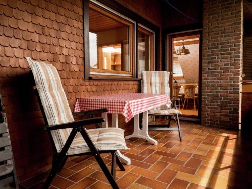 un patio con mesa y 2 sillas en una pared de ladrillo en apartment in Black Forest quiet residential area, en Neuweiler