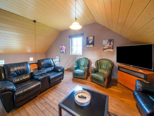 uma sala de estar com mobiliário de couro e uma televisão de ecrã plano em Lovely Holiday Home in Ardennes Luxembourg em La-Roche-en-Ardenne