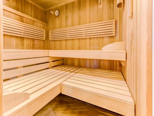 a small sauna with wooden cabinets and shelves at Apartment with wellness oasis in Hellenthal