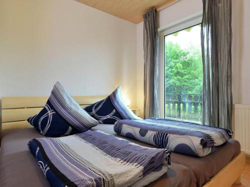 a bedroom with two beds with pillows and a window at Cosy Apartment in Diemelsee with Fenced Garden in Diemelsee