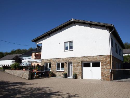 a large white building with a white garage at Quiet apartment along a stream in Halenfeld in Sellerich