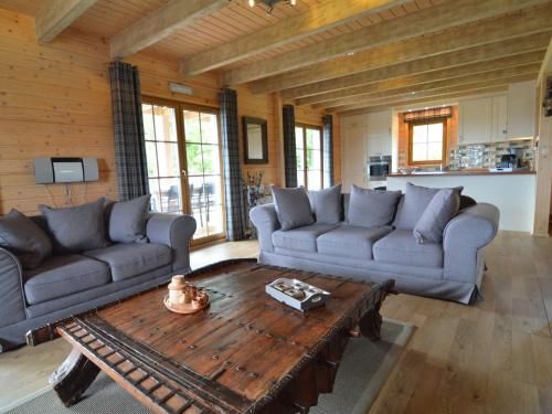 a living room with two couches and a coffee table at Sumptuous Chalet in Septon with Sauna bubblebath in Septon