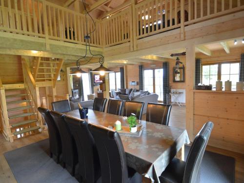 a dining room with a large wooden table and chairs at Sumptuous Chalet in Septon with Sauna bubblebath in Septon