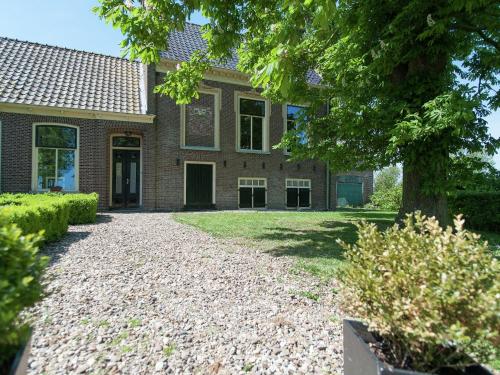 uma casa com uma entrada de cascalho em frente em Charming house in Easterlittens on a Frisian farm em Wommels