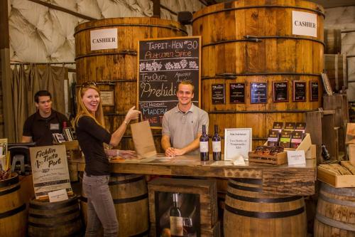 a man and a woman standing behind a counter with wine barrels at Holiday Inn Express & Suites Oakhurst-Yosemite Park Area by IHG in Oakhurst