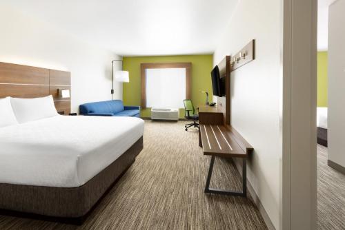 a hotel room with a bed and a tv at Holiday Inn Express & Suites Oakhurst-Yosemite Park Area by IHG in Oakhurst