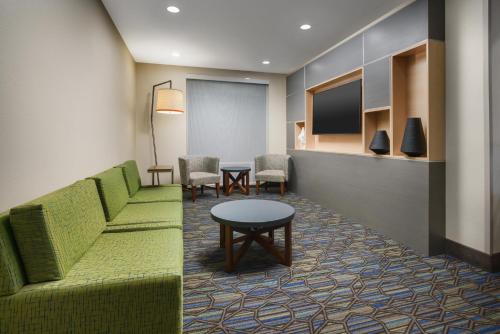a lobby with a couch and chairs and a table at Holiday Inn Express & Suites Oakhurst-Yosemite Park Area by IHG in Oakhurst