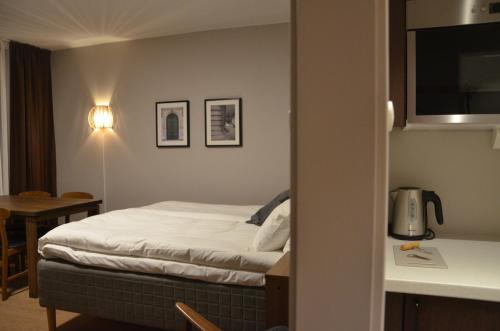 um quarto de hotel com uma cama e uma mesa em Hotell Zäta Longstay em Östersund