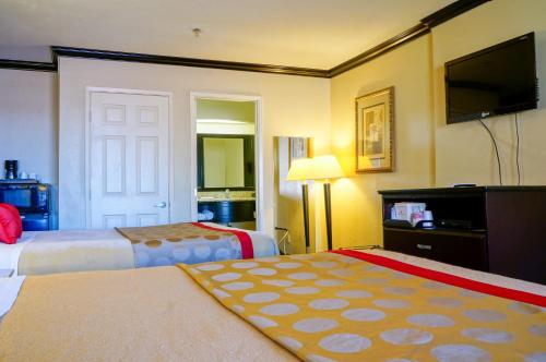 a hotel room with two beds and a flat screen tv at Ramada by Wyndham Ontario Airport & Convention Center in Ontario
