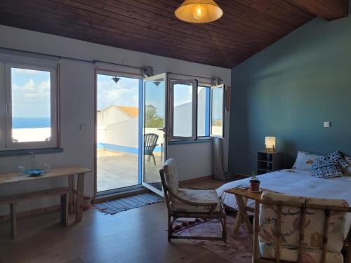 a bedroom with a bed and a view of the ocean at The Handmade House Azores in Porto Formoso