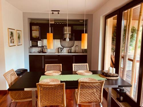 a kitchen with a dining room table and chairs at Apartament Bornholm in Jurata