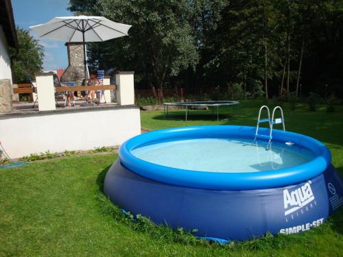 ムラデー・ブキにあるSerene Holiday Home in Mlad Buky with small pool Trampoline Skiing Nearbyの芝生の青い大きなプール(傘付)