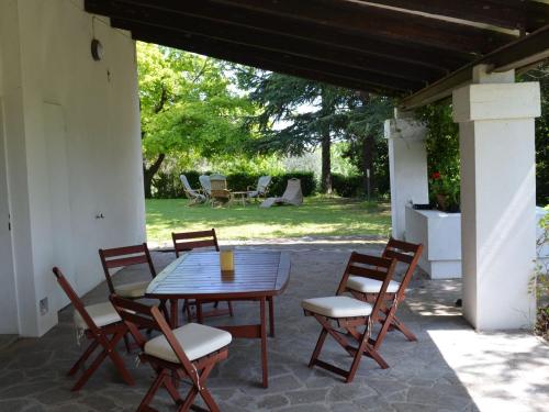 VergianoにあるBelvilla by OYO Villa degli Uliviの木製テーブルと椅子付きのパティオ