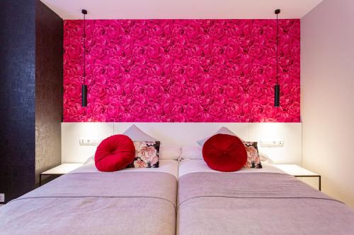 a bedroom with a large bed with red pillows at Fly Rooms Madrid Airport in Madrid