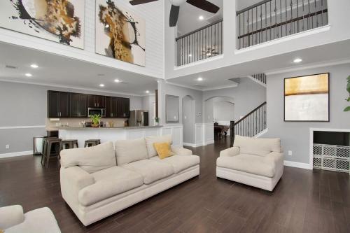 a living room with a white couch and a kitchen at !!!KATY TEXAS GETaWAY!!! in Katy