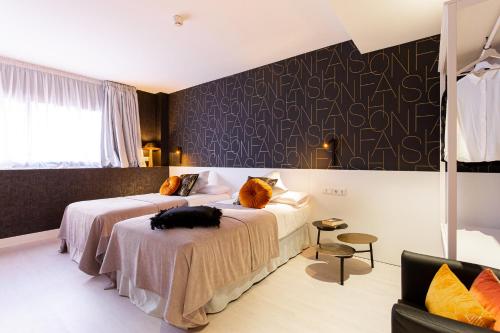 a hotel room with two beds and a couch at Fly Rooms Madrid Airport in Madrid