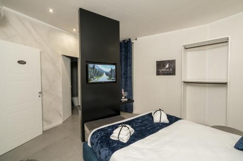 a bedroom with a bed with a tv on the wall at Marmur Suite in Palermo