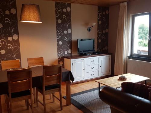 ein Wohnzimmer mit einem Esstisch und einem TV in der Unterkunft Luxurious farmhouse near the ski area in Hellenthal