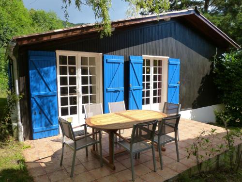 a table and chairs in front of a blue shed at Chalet with garden in the Pyrenees in Roquefort-de-Sault