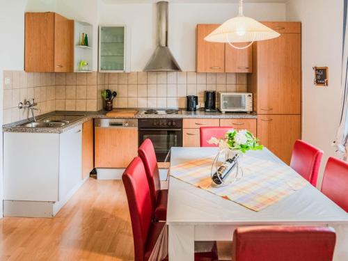 a kitchen with a white table and red chairs at Modernes Familienapartment in Medebach