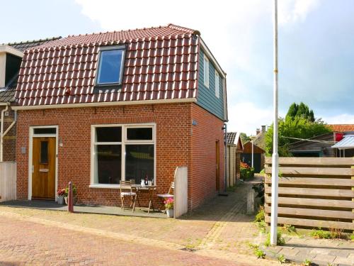 a red brick house with a table in front of it at Holiday home near the Frisian Eleven Cities in Mantgum