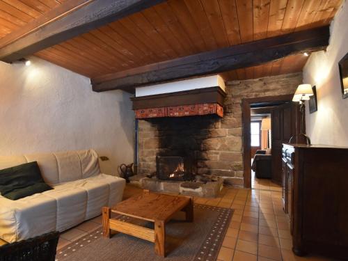 Authentic cottage nearby a beautiful forest في Lierneux: غرفة معيشة مع أريكة ومدفأة