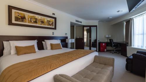 a large bedroom with a large bed and a chair at Hotel Costa Pacifico - Suite in Antofagasta
