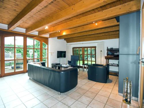 una gran sala de estar con techos de madera y una sala de estar con muebles. en Exclusive holiday home in Uelsen with conservatory, en Uelsen