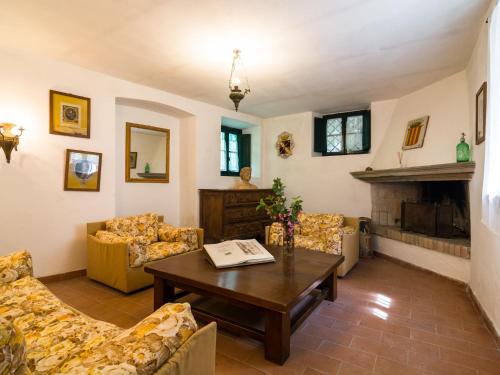 salon z kanapami, stołem i kominkiem w obiekcie Belvilla by OYO l Antica Casa w mieście San Marcello Pistoiese