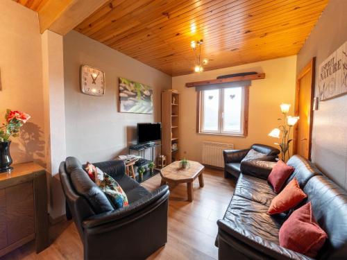 un soggiorno con divani in pelle e tavolo di Pretty Holiday Home near Durbuy and La Roche a Érezée
