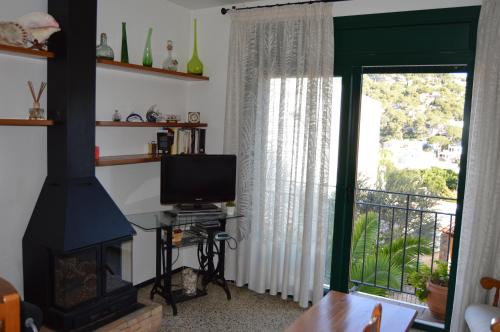 sala de estar con chimenea y TV en La Caseta, en Tamariu