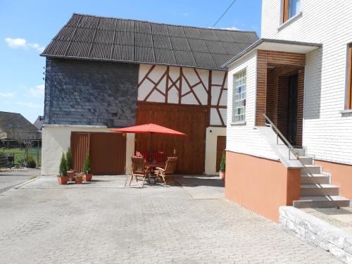 a house with a patio with a table and an umbrella at Holiday home in Haserich with terrace in Haserich