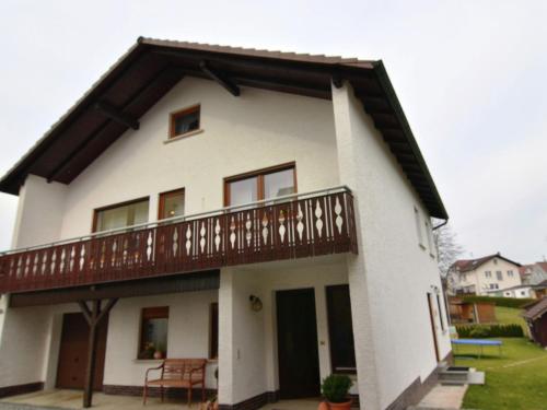 a large white house with a balcony at Wonderful apartment with barrel sauna in Stockheim