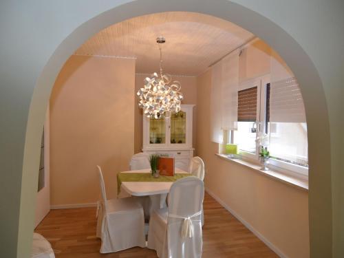 a dining room with a table and chairs and a chandelier at Wonderful apartment with barrel sauna in Stockheim