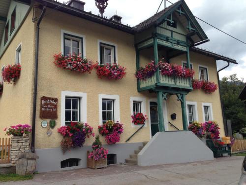 a building with flowers in front of it at Pichlerhof Sommmercard - Urlaub am Bauernhof in Birnberg