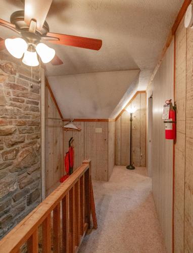 a hallway with a ceiling fan and a stone wall at Swiss Mountain Village in Blowing Rock