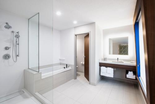 a bathroom with a glass shower and a sink at Holiday Inn Express Hotel & Suites Saskatoon, an IHG Hotel in Saskatoon