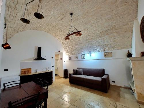 a living room with a couch and a table at GIOVINAZZO HISTORIC APULIA old town stone house with private patio in Giovinazzo