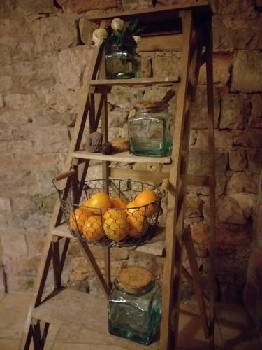a wooden ladder with a basket of fruit on it at Le Jardin Secret in Saint-Antonin-Noble-Val