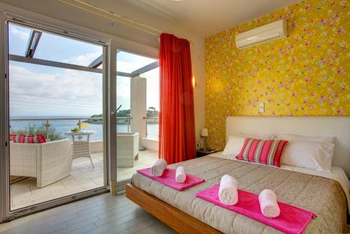 ein Schlafzimmer mit einem großen Bett mit zwei rosa Kissen in der Unterkunft Villa Terra del Nonno with Sea Views & Pool in Gaios
