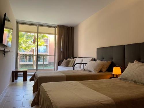 a hotel room with two beds and a window at Herdade dos Salgados - Vila das Lagoas - Private Apartaments in Albufeira