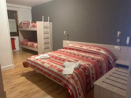 ボルノにあるHotel ValleD'Oroのベッドルーム1室(赤い毛布とはしご付きのベッド1台付)