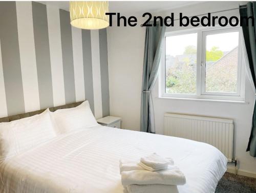 a bedroom with a white bed with a window at Oxford city centre house/walkable to University in Oxford