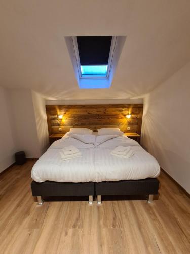 a bedroom with a large white bed with a skylight at Hotel Pension Annerlhof in Maria Alm am Steinernen Meer