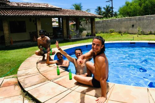 um grupo de pessoas sentadas numa piscina em Hostel Terra do Sol em Porto Seguro