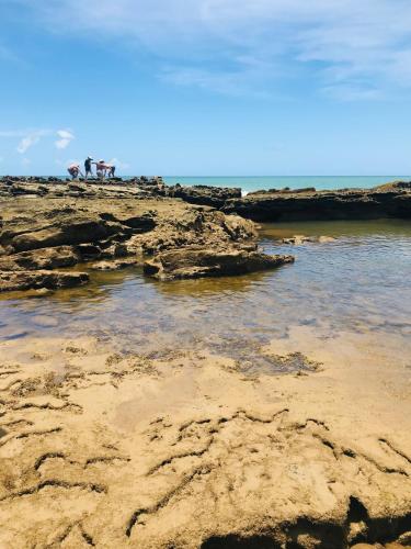 a group of people standing on a rocky beach at Terra do Sol Pousada e Hostel in Porto Seguro