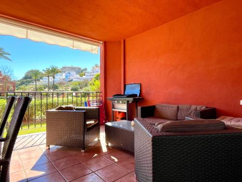 een woonkamer met een bank, een tafel en een raam bij Pool View GOLF FAMILY Ground Floor Terrace with barbecue in Mijas Costa in Mijas