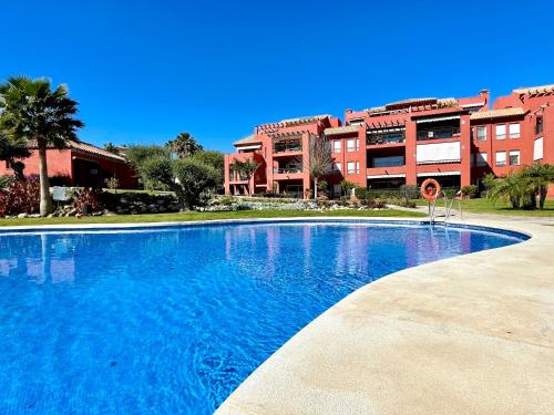 een groot blauw zwembad voor een gebouw bij Pool View GOLF FAMILY Ground Floor Terrace with barbecue in Mijas Costa in Mijas