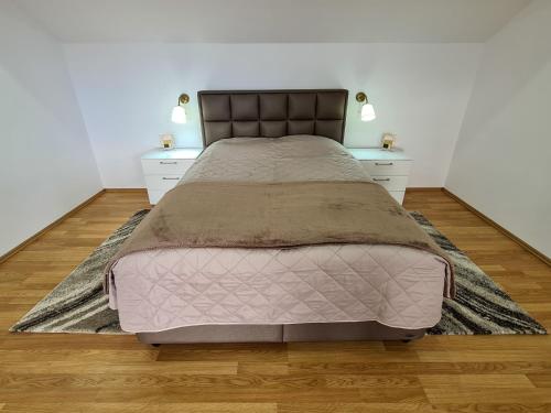 - une chambre avec un grand lit et 2 tables de chevet dans l'établissement Vila Sanne Brașov , Hălchiu, à Heldsdorf