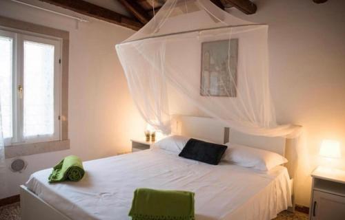 1 dormitorio con 1 cama blanca con dosel en SALAMON GUEST HOUSE, en Venecia
